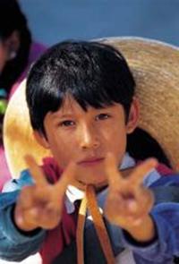 Young boy raising peace symbol on both hands demonstrating alternatives to aggression and violence